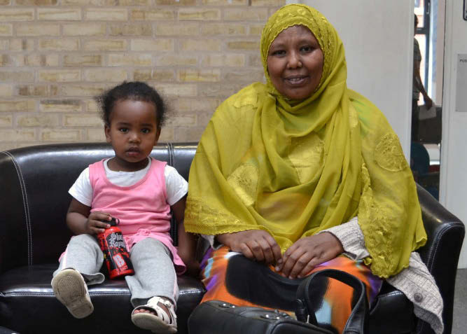 Mother in traditional dress with child in waiting room